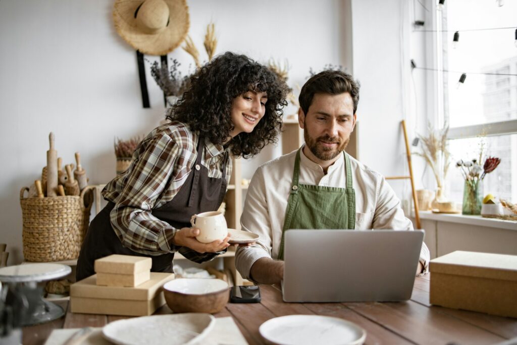 Caucasian couple of co-workers work on small pottery production business.